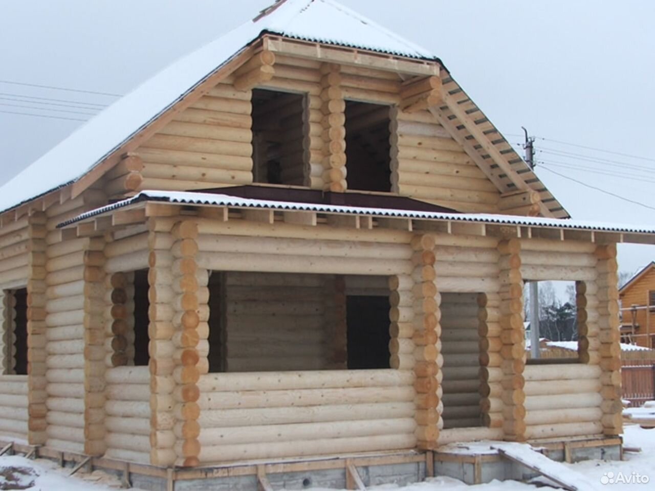 Деревянный бревенчатый дом с полувальмовой крышей